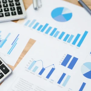 Calculator and charts on a desk representing budgeting strategy.