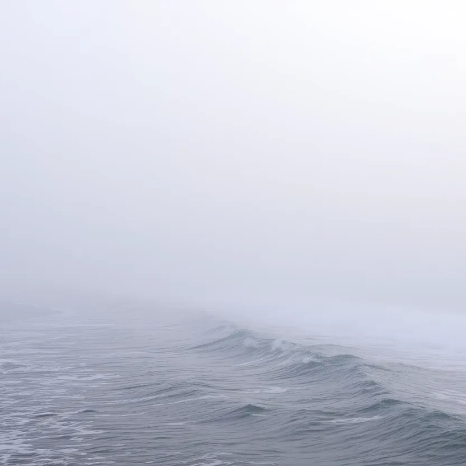 Thick fog rolling over the shoreline of Lake Michigan.