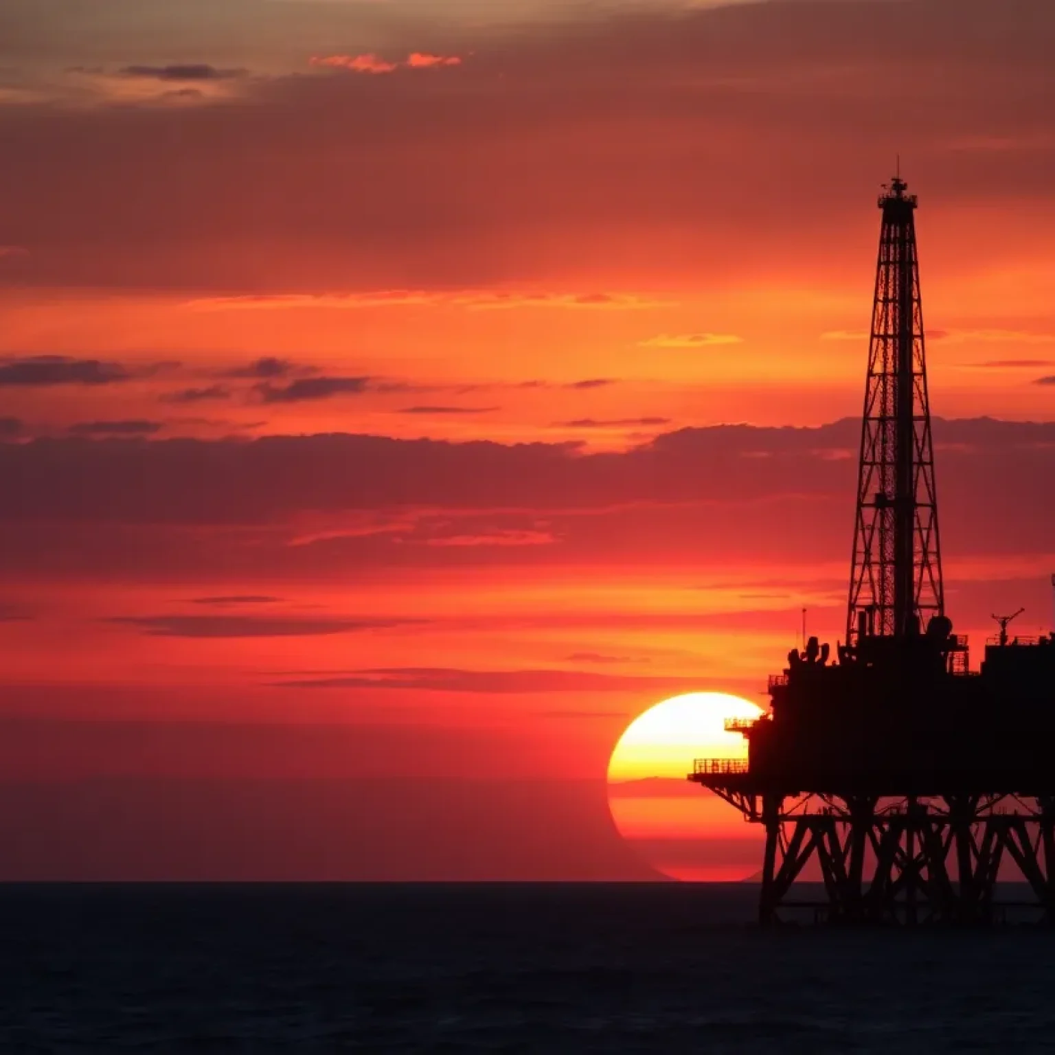 An oil rig at sunset symbolizing OPEC+ oil production.