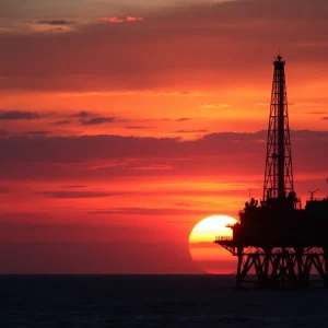 An oil rig at sunset symbolizing OPEC+ oil production.
