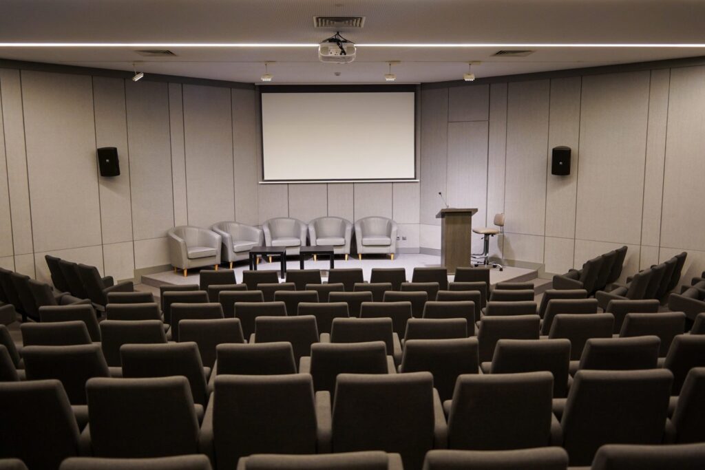 Empty auditorium with rows of chairs facing a stage