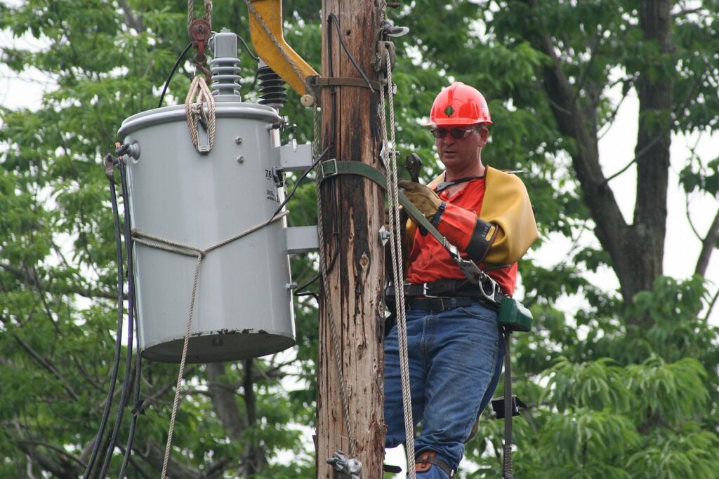 Lineman changing a transformer on a utility pole